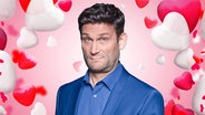 Christian Ehring inmitten von Herzen zum Valentinstag. (extra 3 vom 13.02.2025 im Ersten) © NDR 