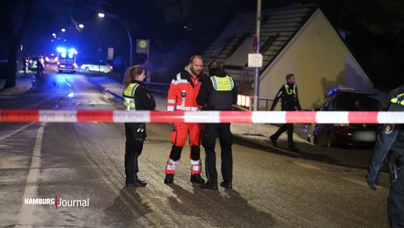 Einsatzkräfte von Polizei und Rettungsdienst in der Nacht hinter einer Absperrung. © Screenshot 