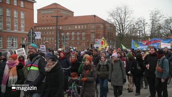 Eine Klimastreik Demonstration mit Transparenten und winterlich gekleideten Menschen. © Screenshot 