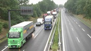 Fahrende Lkw auf einer Straße. © Screenshot 