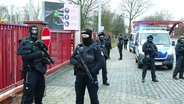 Bewaffnete Polizisten und Zoll in Uniform vor der Müllverbrennungsanlage in Hamburg. © Screenshot 