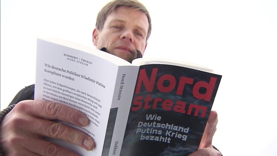 Autor Steffen Dobbert mit seinem Buch Nord Stream. © Screenshot 