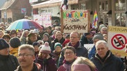 Demonstranten mit bunten Plakaten. © Screenshot 