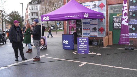 Wahlkampfstand der Partei "Volt" mit lila Plakaten. © Screenshot 