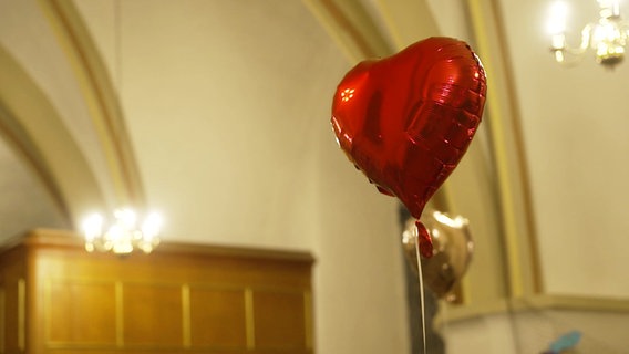 Ein Herzluftballon in einer Kirche. © Screenshot 