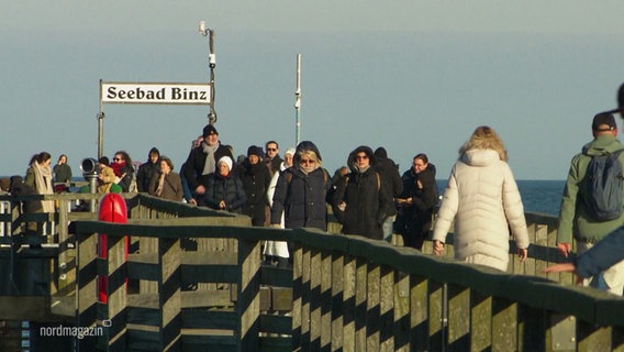 Viele Menschen spazieren auf der Seebrücke in Binz. © Screenshot 