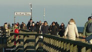 Viele Menschen spazieren auf der Seebrücke in Binz. © Screenshot 