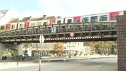 Ein U-Bahn-Zug fährt über eine Hochbahnbrücke in der Hamburger Innenstadt. © Screenshot 