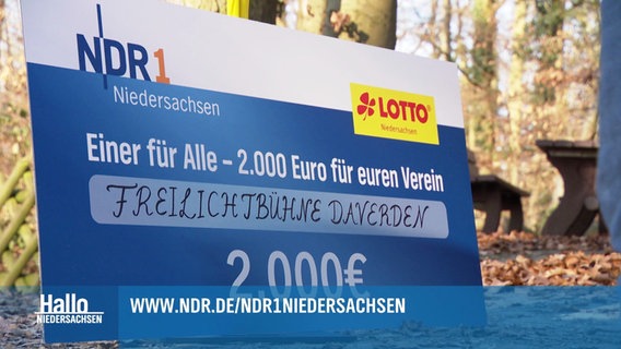 Schild als überdimensioniertes Los mit den Logos von NDR 1 und Lotto für die Aktion "Einer für alle - 2.000 Euro für euren Verein", gewonnen hat die Freilichtbühne Daverden. © Screenshot 