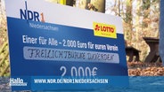 Schild als überdimensioniertes Los mit den Logos von NDR 1 und Lotto für die Aktion "Einer für alle - 2.000 Euro für euren Verein", gewonnen hat die Freilichtbühne Daverden. © Screenshot 