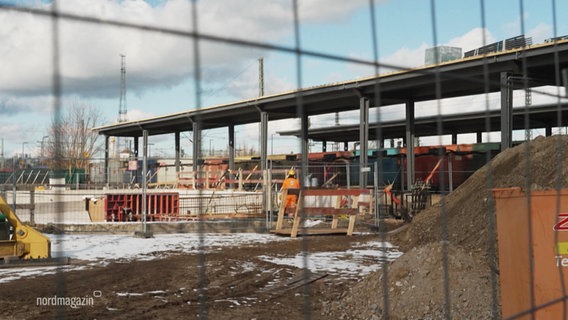 Blick durch einen Baustellenzaun: Eine Baustelle an einem Bahnhof. © Screenshot 