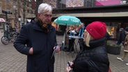 Mathias Middelberg (CDU) spricht mit einer Frau. © Screenshot 