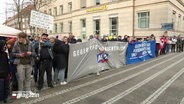 Demonstration vor einer Commerzbank-Filiale. Menschen halten Banner mit politischen Botschaften gegen Rechtsruck und die AfD. © Screenshot 