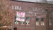 Ein Banner mit der Aufschrift "Kein Platz für Rassismus" hängt an einer Fassade. © Screenshot 