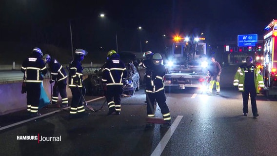 Einsatzkräfte der Feuerwehr fegen Scherben und Autzoteile von der Farbahn. © Screenshot 