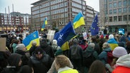 Auf einer Demonstration sind Ukraine- und NATO-Flaggen zu sehen. © Screenshot 