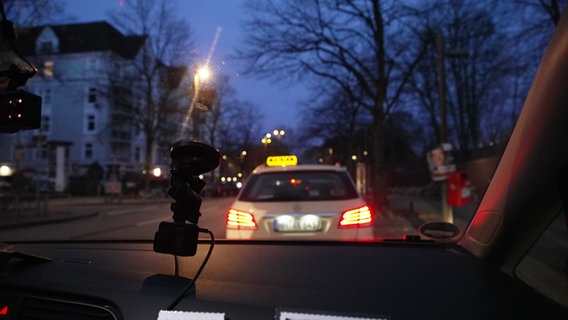 Ein Taxi mit leuchtendem Taxi-Schild in der Dämmerung © Screenshot 