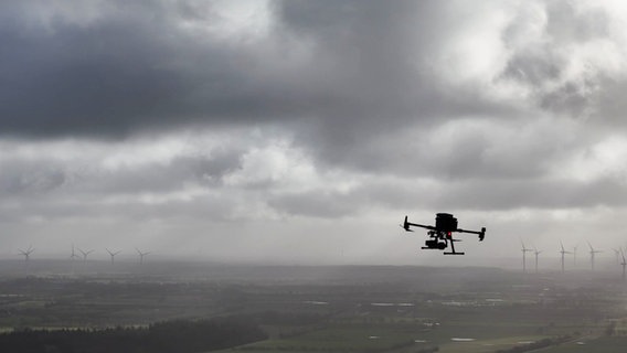 Eine fliegende Drohne vor grauen Wolken © Screenshot 