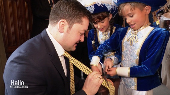 Der OB von Braunschweig lässt sich zu Karneval die Kravatte von Kindern abschneiden. © Screenshot 