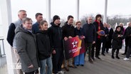 Vertreterinnen und Vertreter aus verschiedenen Sportarten und der Stadt Hannover halten ein Banner mit der Aufschrift "Finals 2026". © Screenshot 