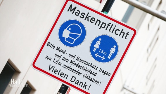 Ein Schild weist aus Maskenpflicht und Mindestabstand hin. © Screenshot 