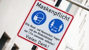 Ein Schild weist aus Maskenpflicht und Mindestabstand hin. © Screenshot 