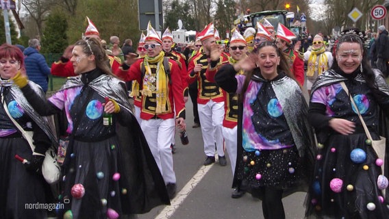 Bunt verkleidete Menschen beim Straßenkarneval in Dömitz winken der Menge zu. © Screenshot 