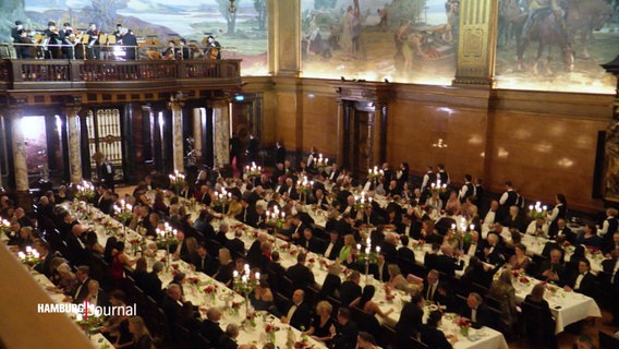 Blick in den großen Festsaal des Hamburger Rathauses: Beim Matthiae-Mahl sind viele lange weiße Festtafeln aufgestellt. © Screenshot 