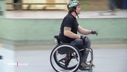 Ein Junge im Rollstuhl fährt in einem Skatepark. © Screenshot 