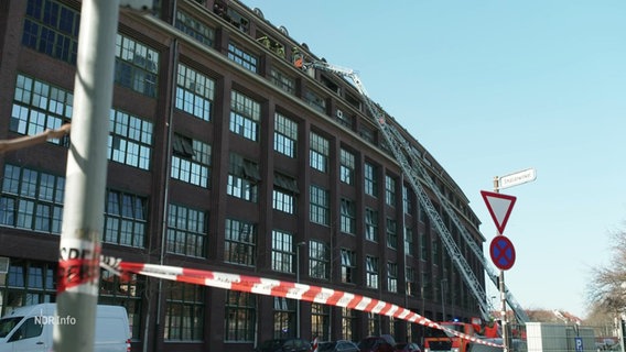 Die abgesperrte Fassade des Continentalwerks. Feuerwehleitern führen zur zerstörten Fensterfront des obersten Stockwerkes. © Screenshot 