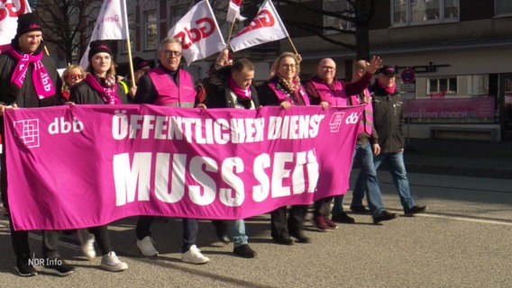 Streikende halten ein Transparant mit der Aufschrift "Öffentlicher Dienst muss sein". © Screenshot 