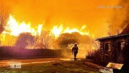 Einsatzkräfte der Feuerwehr löschen einen Brand. © Screenshot 