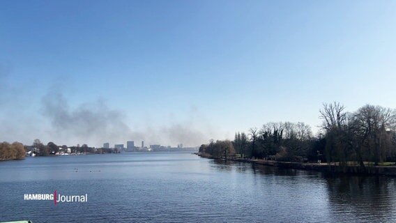 Im blauen Himmel über der Alster steigt eine dunkle Rauchsäule auf. © Screenshot 