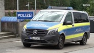 Ein Polizeifahrzeg steht vor einer Polizeiwache. © Screenshot 