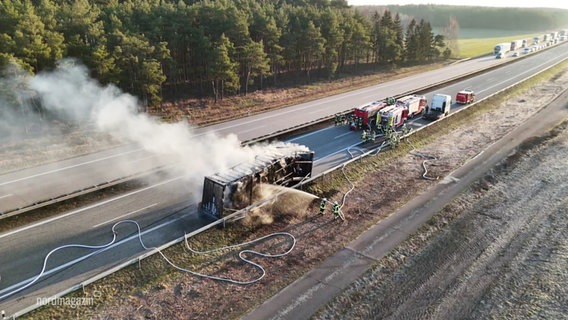 Einsatzkräfte der Feuerwehr löschen einen ausgebrannten Lkw. © Screenshot 