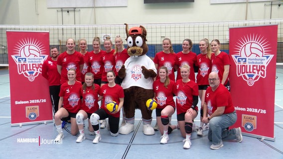 Die Volleyballerinnen stehen gemeinsam mit einem Maskottchen für ein Teamfoto zusammen. © Screenshot 