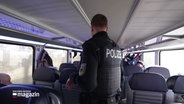 Ein Polizist geht durch einen Regionalzug. © Screenshot 