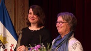 Gleichstellungsministerin Jaqueline Bernhardt (Die Linke) mit der Rostocker Unternehmerin Yvette Dinse bei der Verleihung der Auszeichnung "Frau des Jahres". © Screenshot 