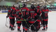 Die Eishockey-Spieler der Crocodiles Hamburg umarmen sich auf dem Eis. © Screenshot 