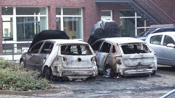 Mehrere Fahrzeuge auf einem Parkplatz sind ausgebrannt. © Screenshot 