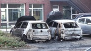 Mehrere Fahrzeuge auf einem Parkplatz sind ausgebrannt. © Screenshot 