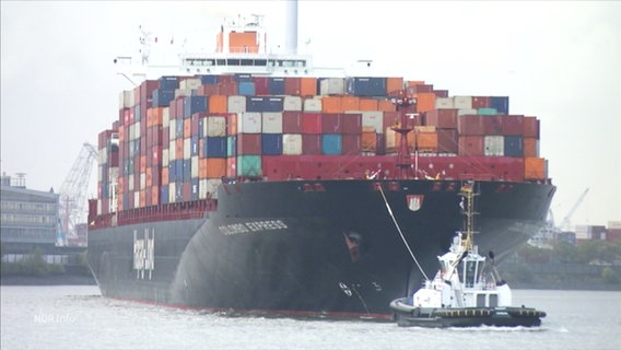 Ein großes Containerschiff wird von einem Schlepper gezogen. © Screenshot 