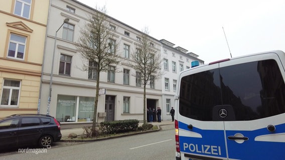 Ein Polizeiauto steht in einer Straße vor einem Wohnhaus. © Screenshot 