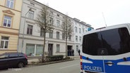 Ein Polizeiauto steht in einer Straße vor einem Wohnhaus. © Screenshot 