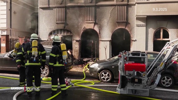 Feuerwehrleute stehen vor einem ausgebrannten Gebäude. © Screenshot 