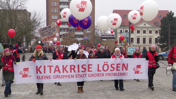 Ein Streik mit vielen Menschen, vorne eine Reihe die ein Schild hochhält. © Screenshot 