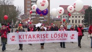 Ein Streik mit vielen Menschen, vorne eine Reihe die ein Schild hochhält. © Screenshot 