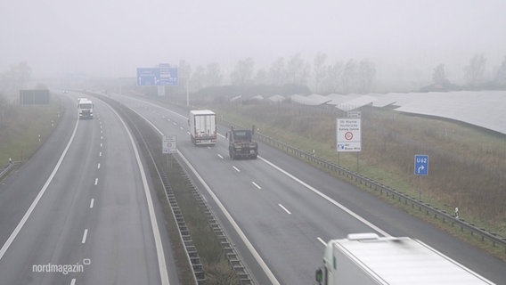 Vier LKWs fahren auf der Autobahn im Nebel. © Screenshot 