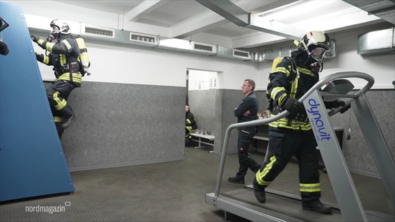 Zwei Feuerwehrmänner trainieren auf Fitnessgeräten und einem Laufband. © Screenshot 