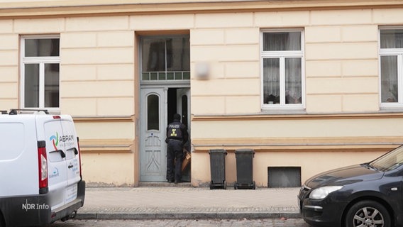 Ein Polizist geht in ein Wohnhaus. © Screenshot 